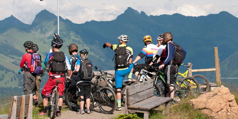 A group of people standing on top of a hill with bicycles.