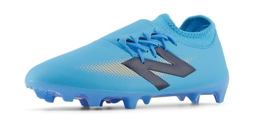 New Balance soccer cleats on a grass pitch