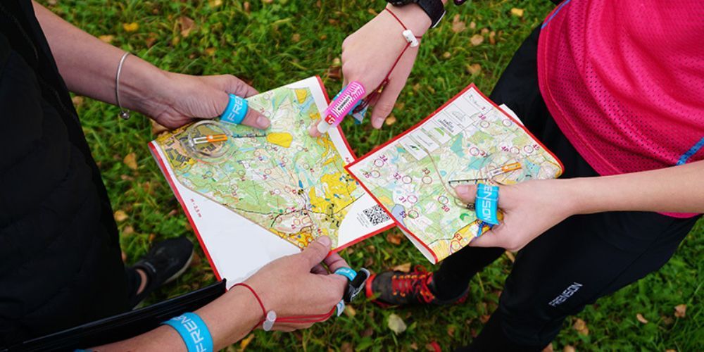 A group of people are holding maps in their hands.