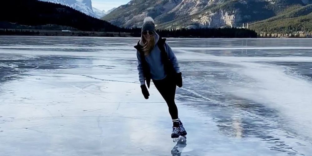 A woman is ice skating on a frozen lake.