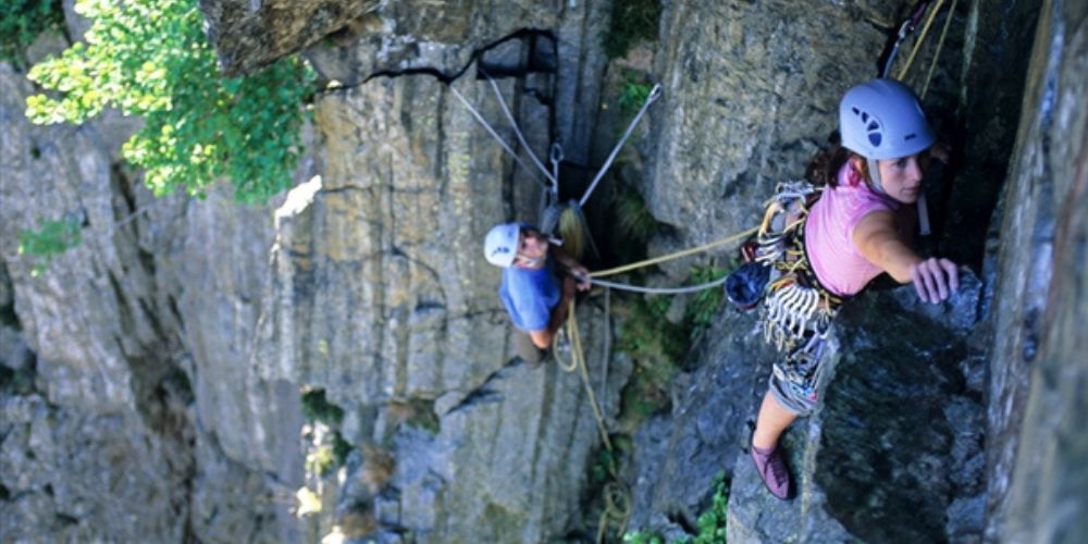 A group of people are climbing up a rock wall.