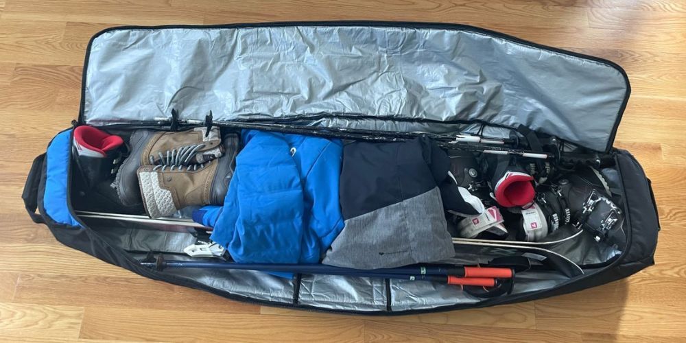 A snowboard is sitting in a bag on a wooden floor.