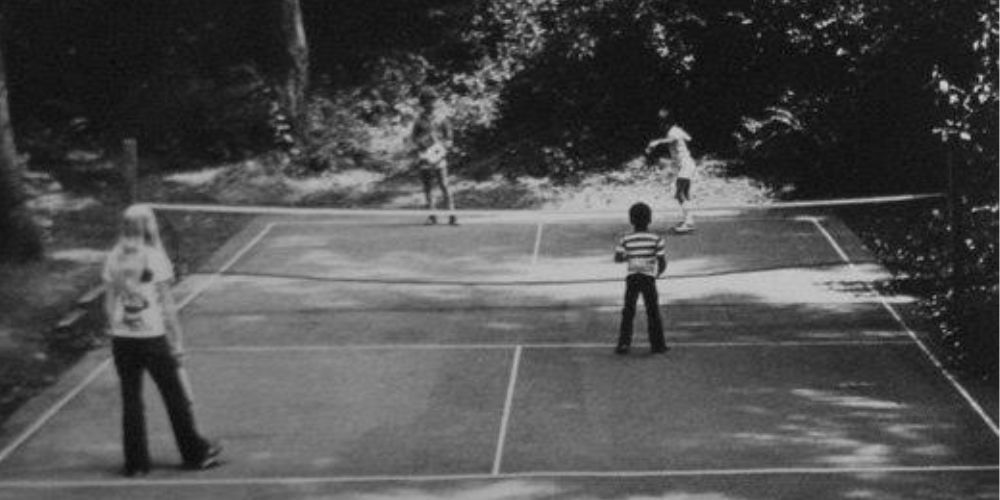 A black and white photo of people playing pickleball