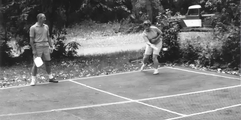 A black and white photo of people playing pickleball