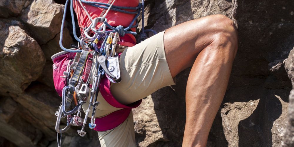 A person is sitting on a rock with a backpack on their back.