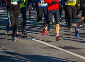 A group of people are running a marathon on a city street.