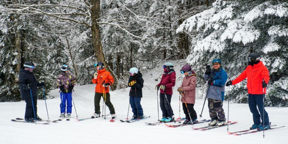 A group of people are standing in the snow on skis.