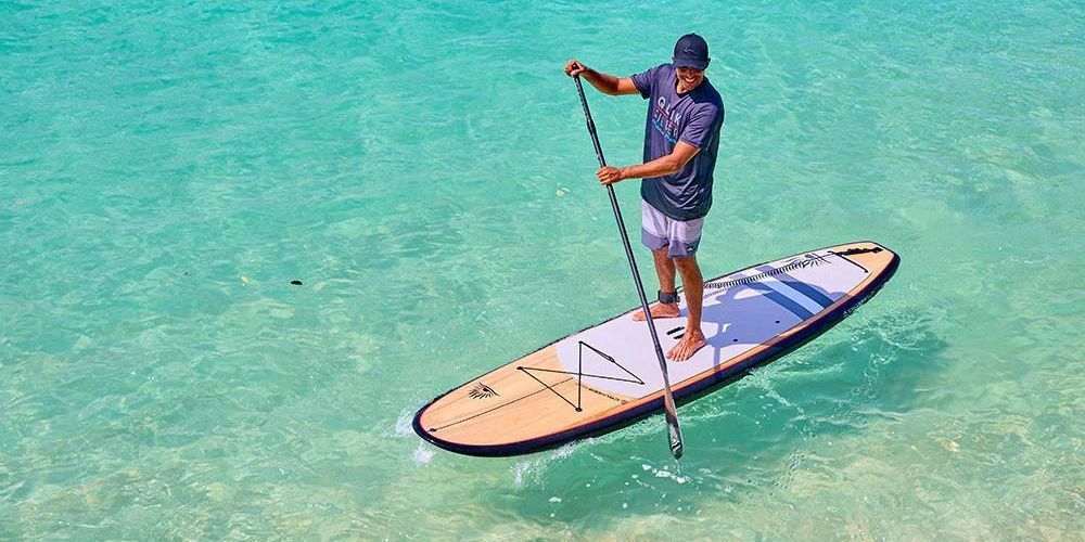 man paddleboarding on clear blue water