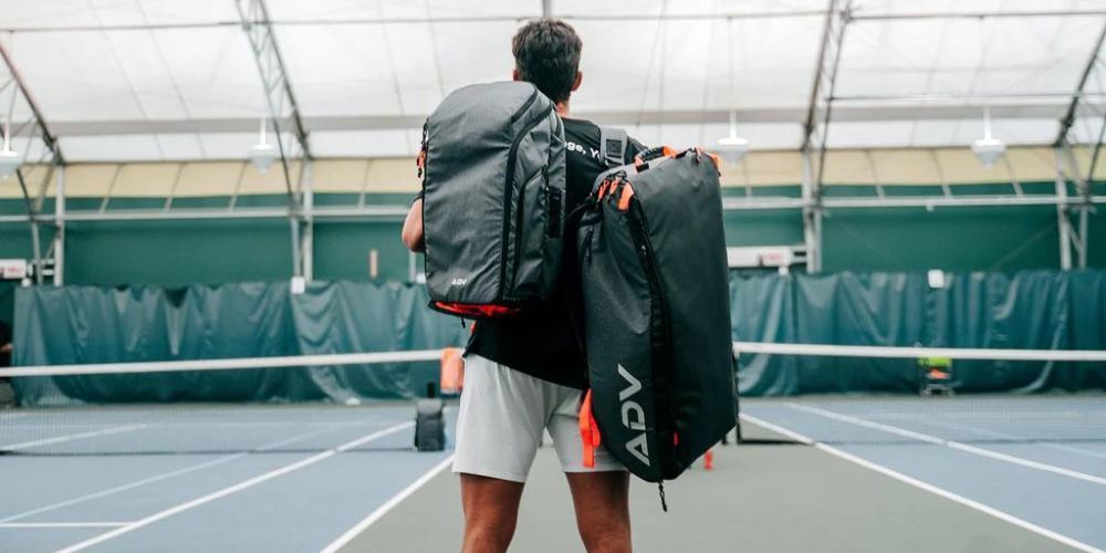 man walking with a tennis backpack