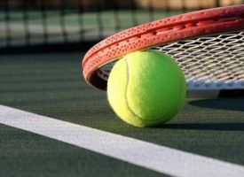 A tennis ball and racket on a tennis court.
