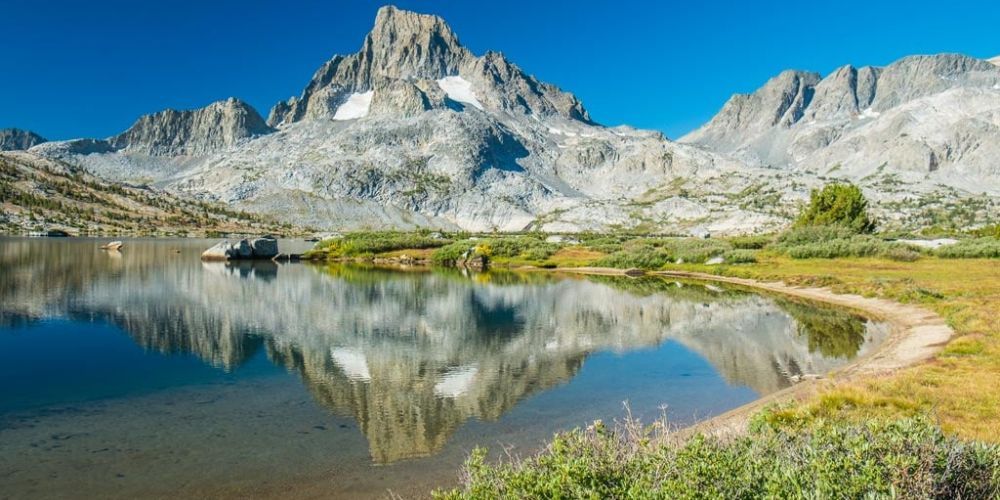 A mountain is reflected in a lake in the mountains.