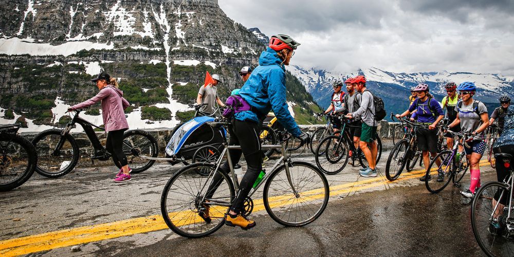 A group of people are riding bicycles down a wet road.