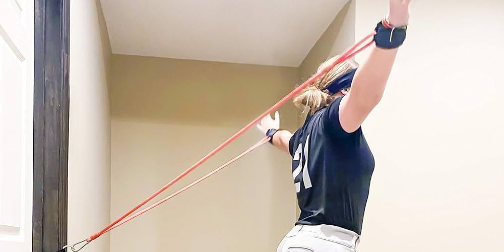 A woman is doing exercises with a red resistance band.