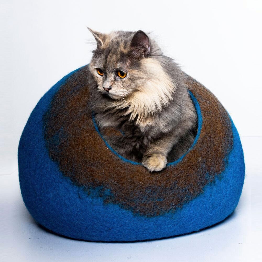 cat sleeping in a wool cave bed