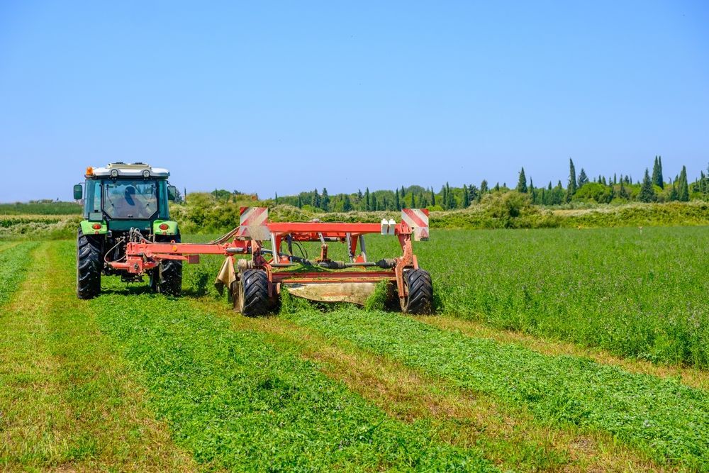 Green Tractor Mowing a Field — Paul’s Tyres & Farm Maintenance in Mudgee, NSW