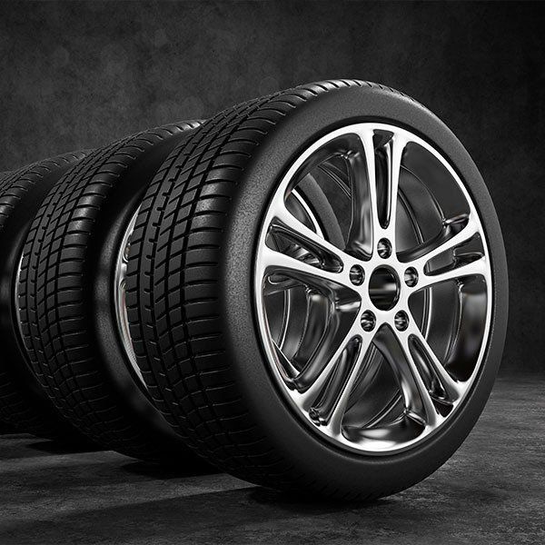 Four Car Tires With Silver Rims on a Dark Gray Surface — Paul’s Tyres & Farm Maintenance in Apsley, NSW