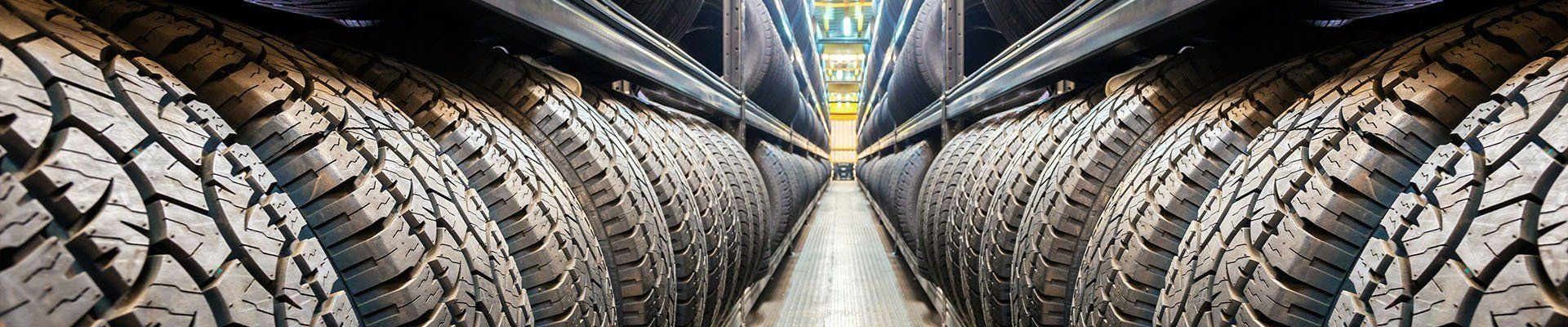 Rows of Black Tires Neatly Stacked on Metal Shelves — Paul’s Tyres & Farm Maintenance in Apsley, NSW