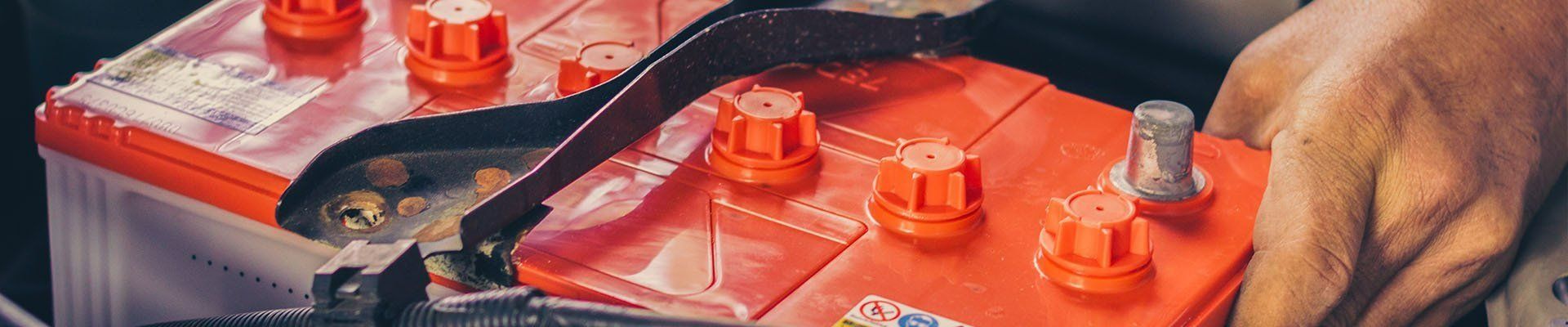 Car Batteries Being Handled by a Person — Paul’s Tyres & Farm Maintenance in Apsley, NSW