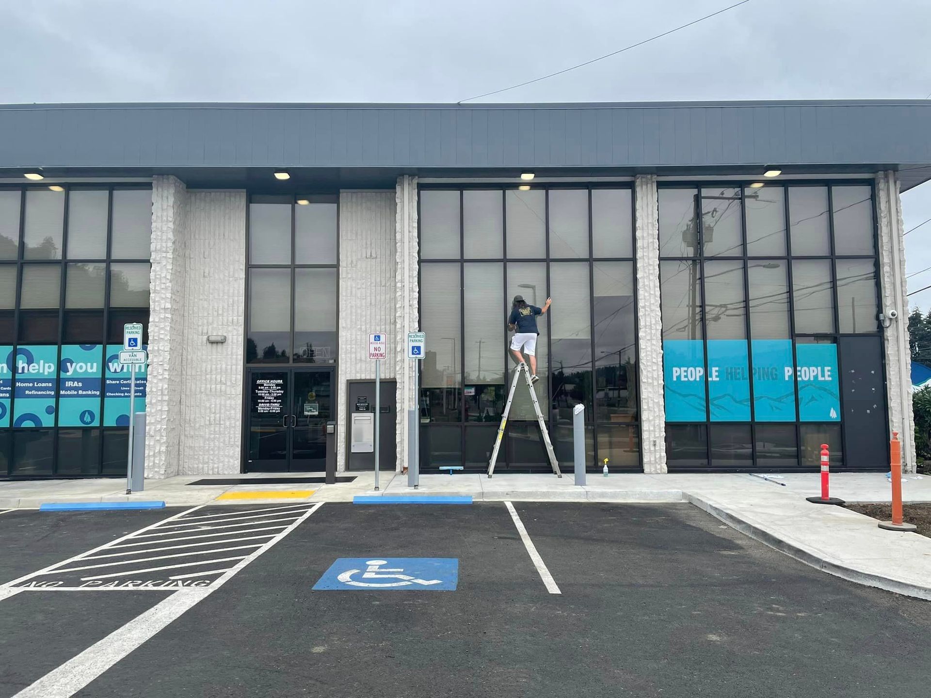 A team member from Infinity Professional Cleaners diligently cleaning commercial windows