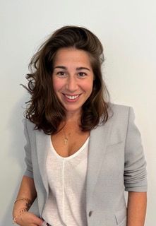 The woman is wearing a black shirt and smiling for the camera.