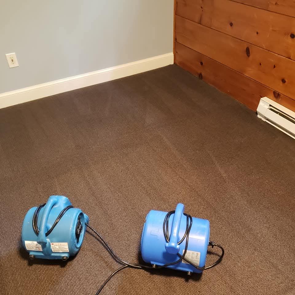 A person is cleaning a white carpet in a living room in Vancouver.