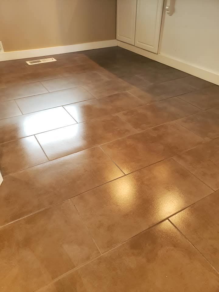 A person is applying a sealant to a tile floor.