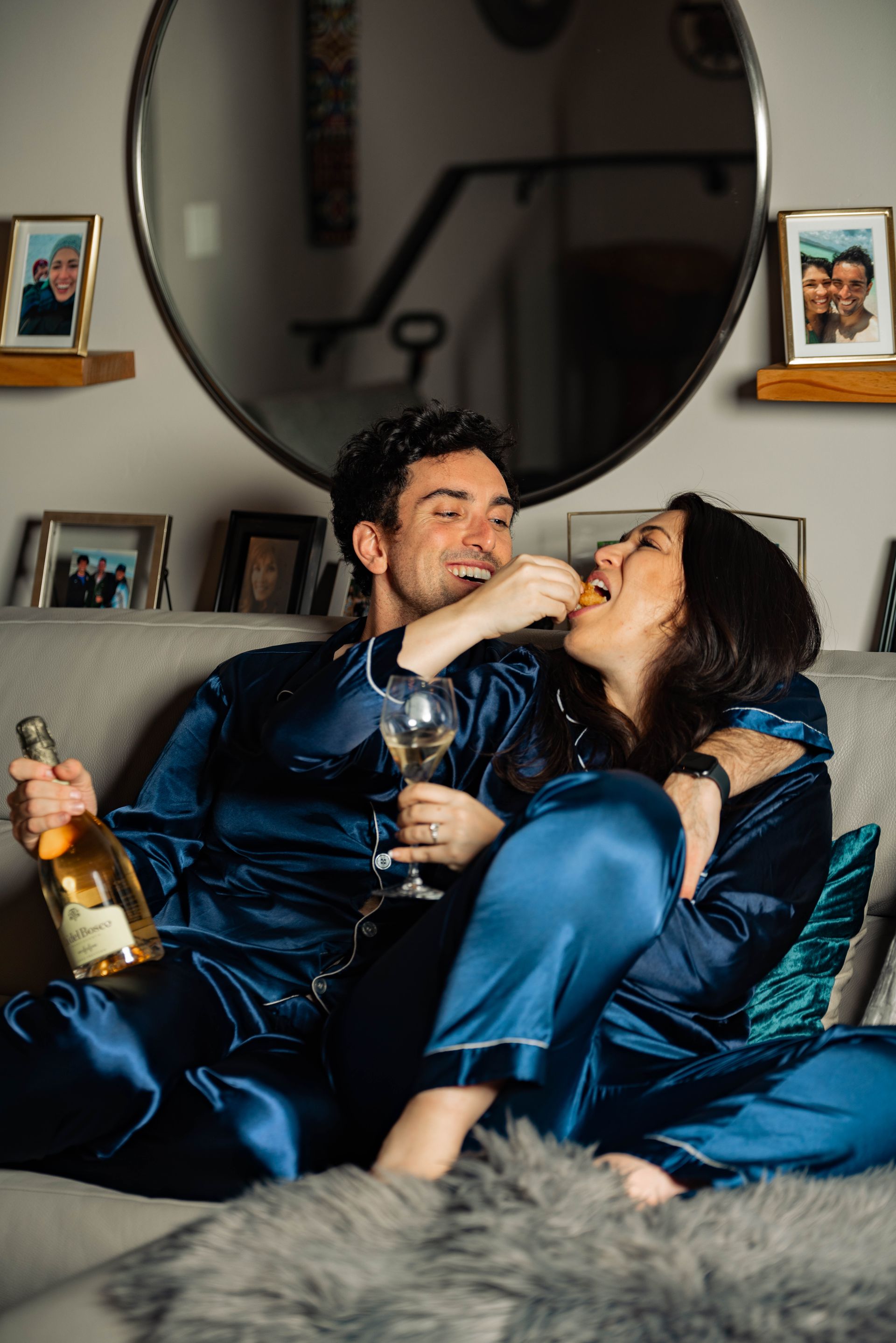A couple at home sipping champagne together.