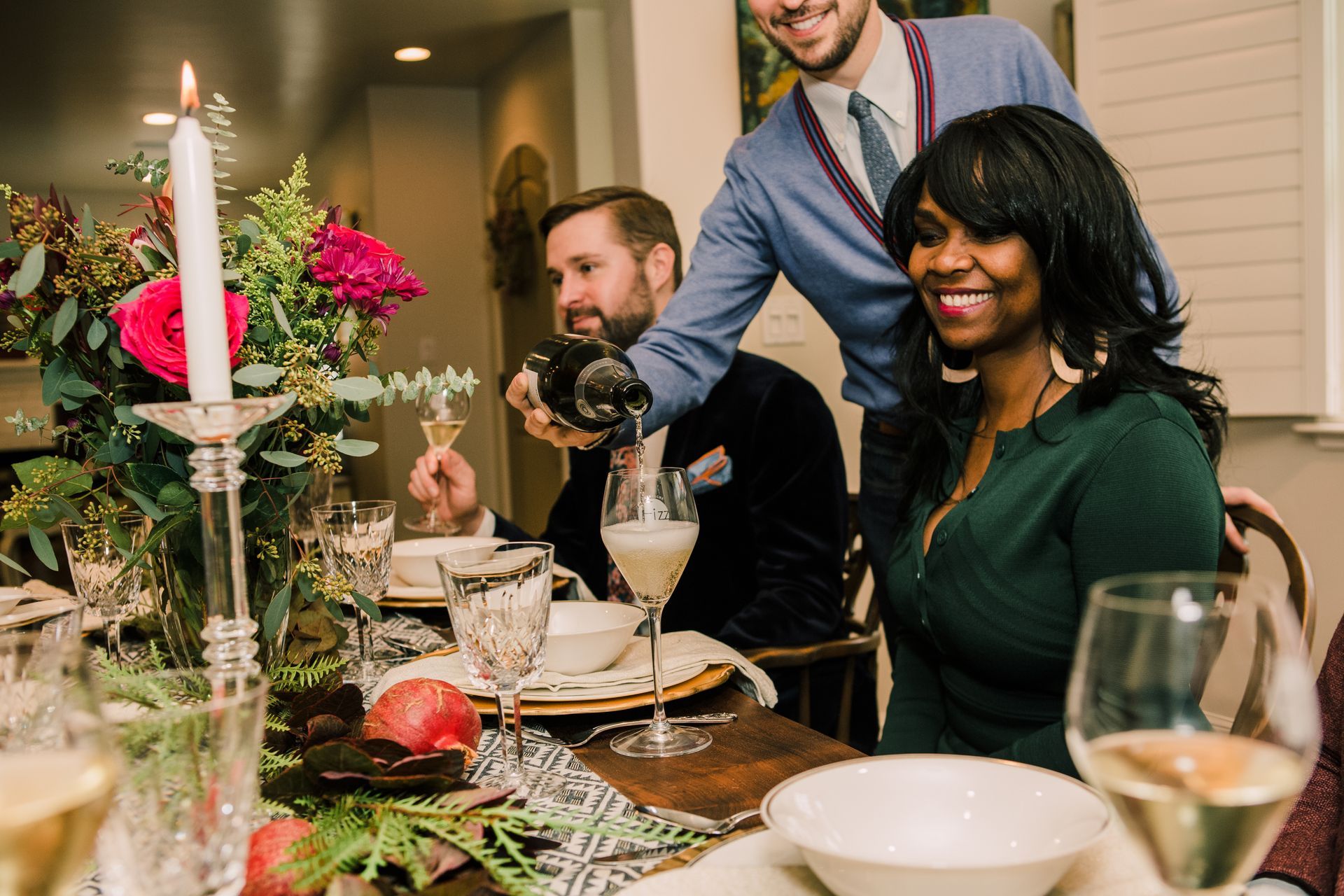 People gathered around a table enjoying champagne.
