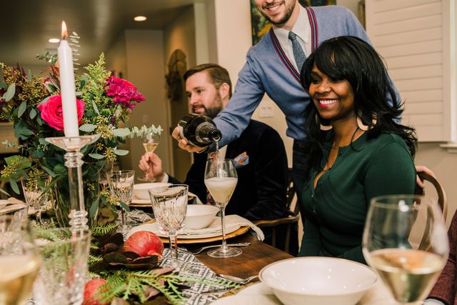 People gathered around a table enjoying champagne.