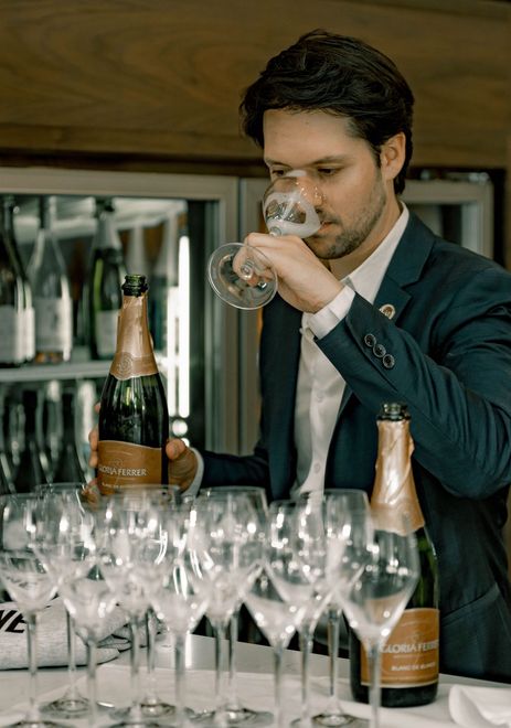 Chief champagne officer smelling a glass of champagne.