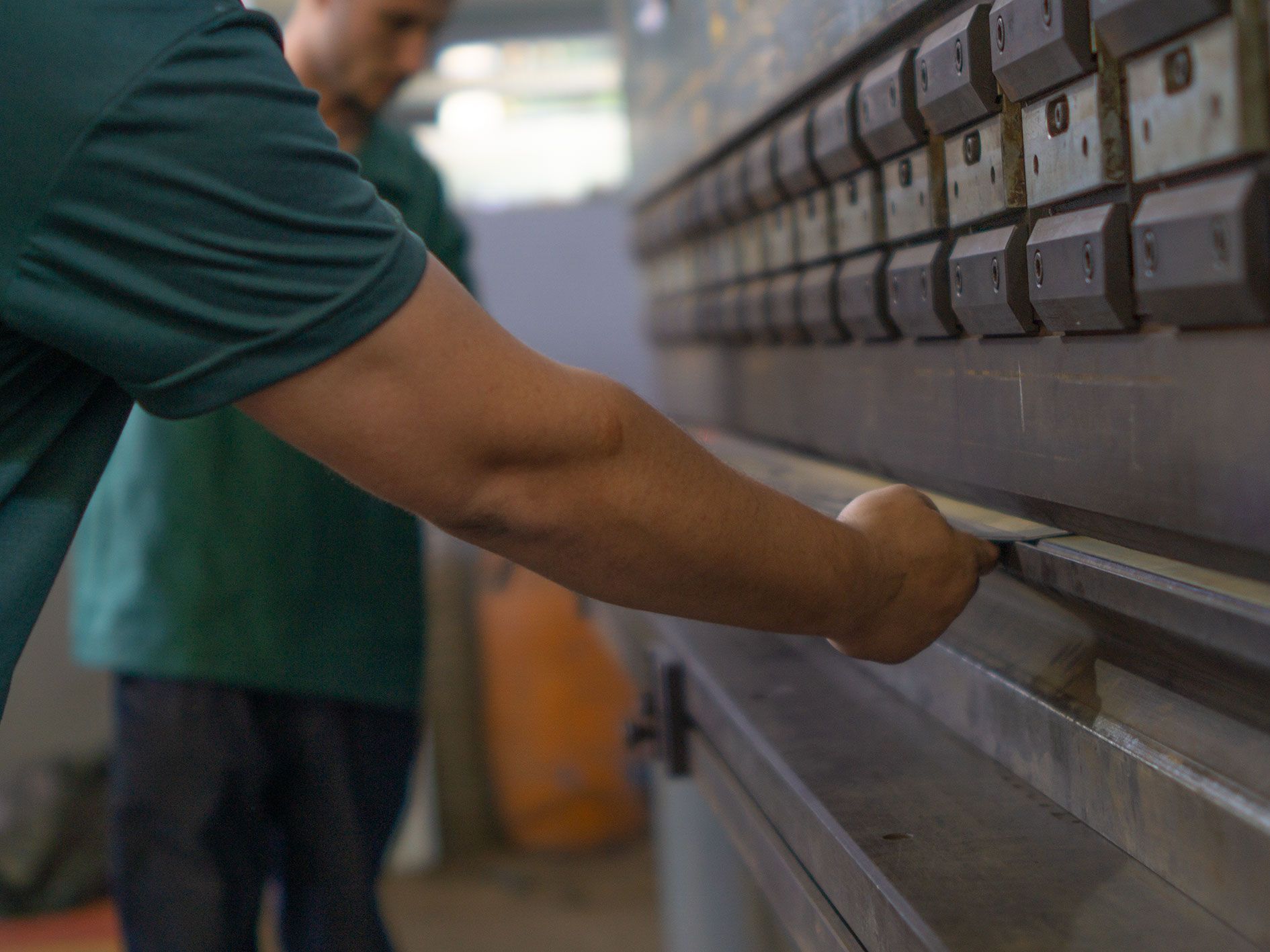 Um homem está trabalhando em uma máquina em uma fábrica.