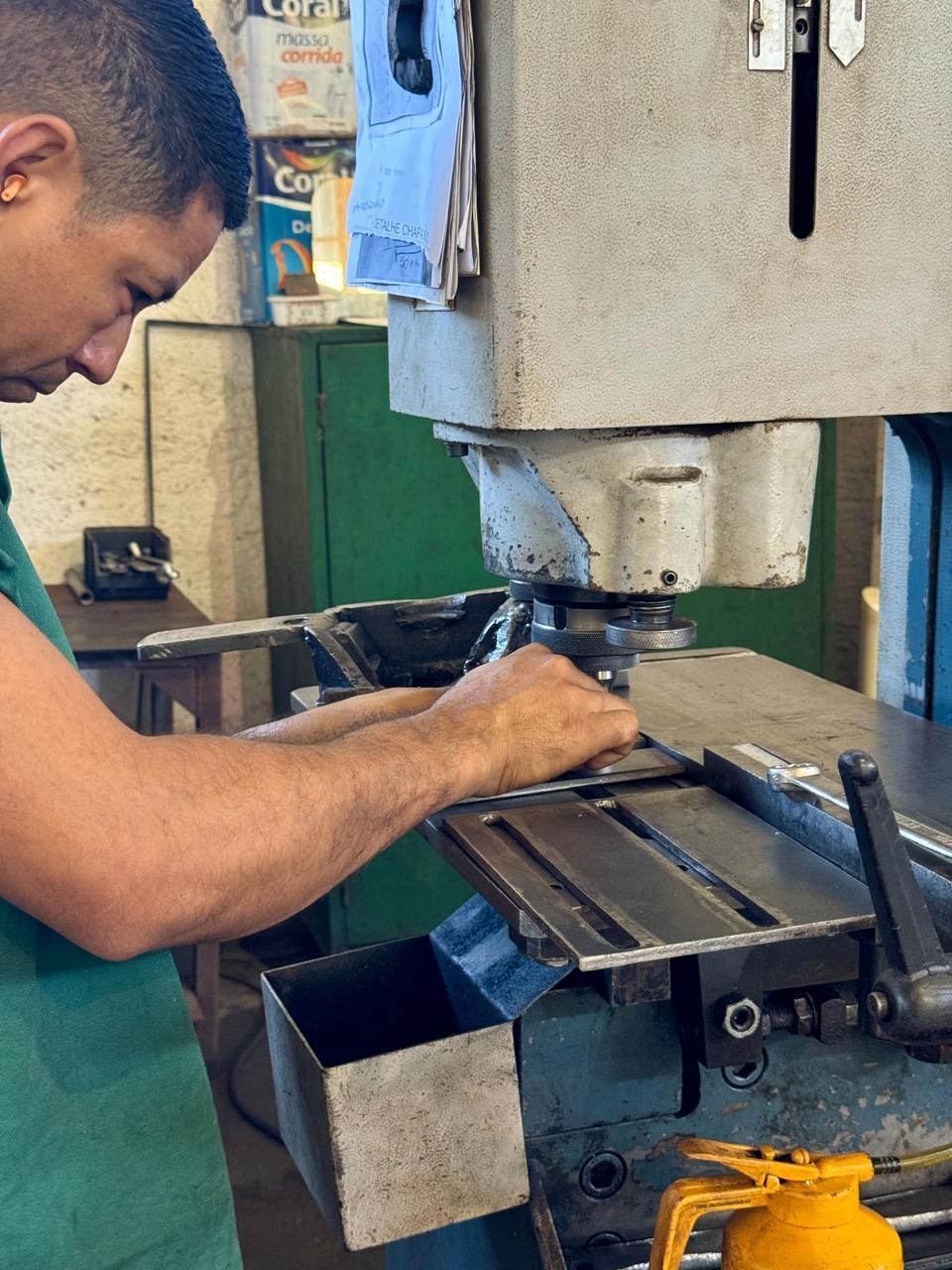 A man in a green shirt is working on a machine
