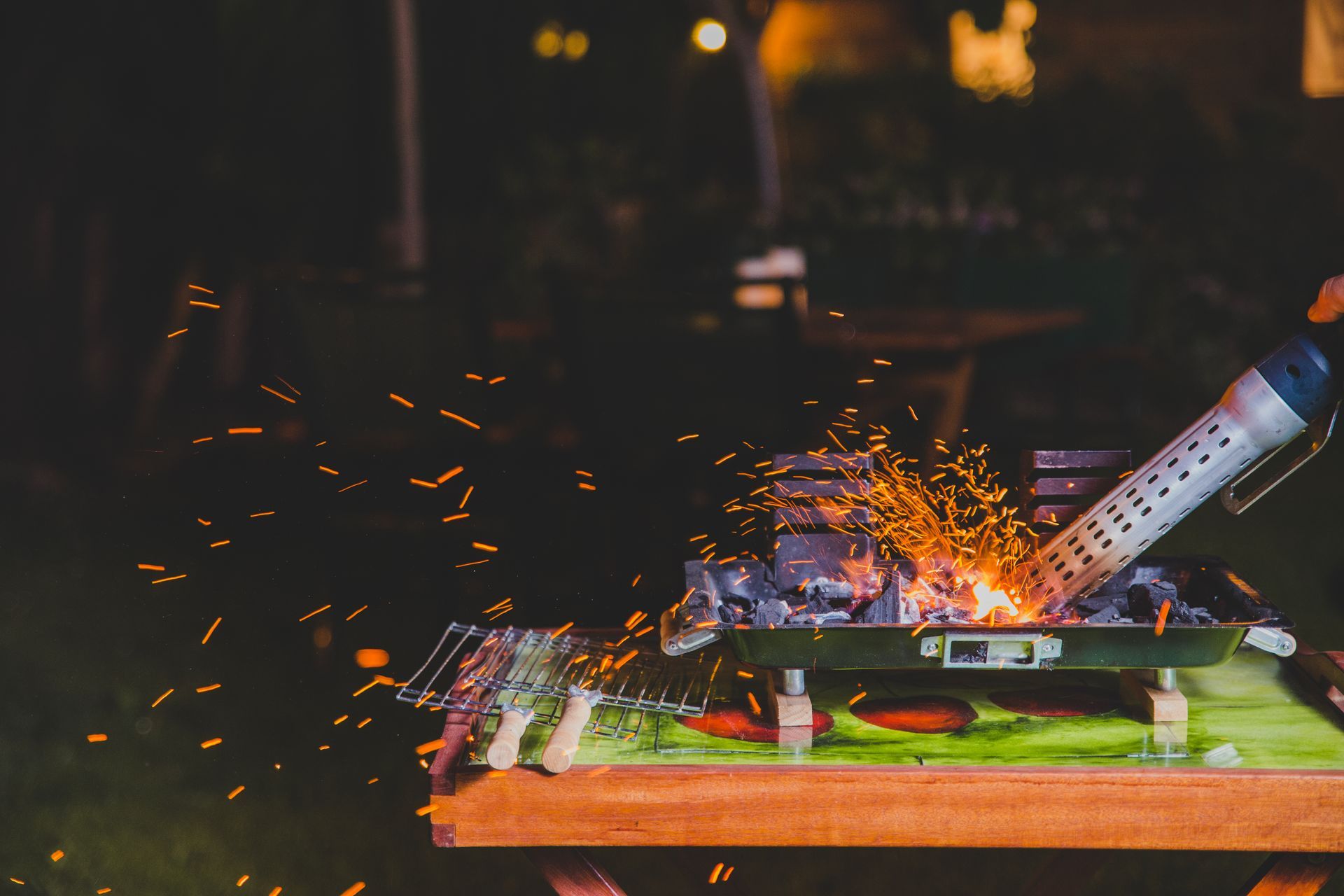 Uma pessoa está cozinhando comida em uma grelha à noite.