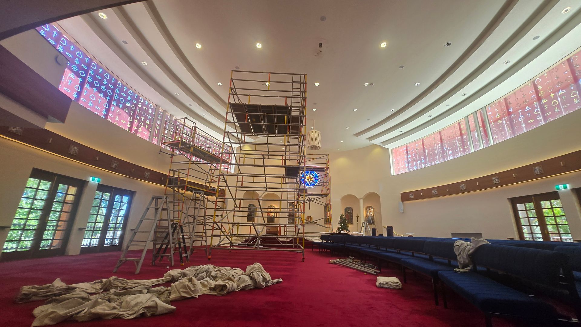 A man is leaning on a ladder next to a yellow shipping container.