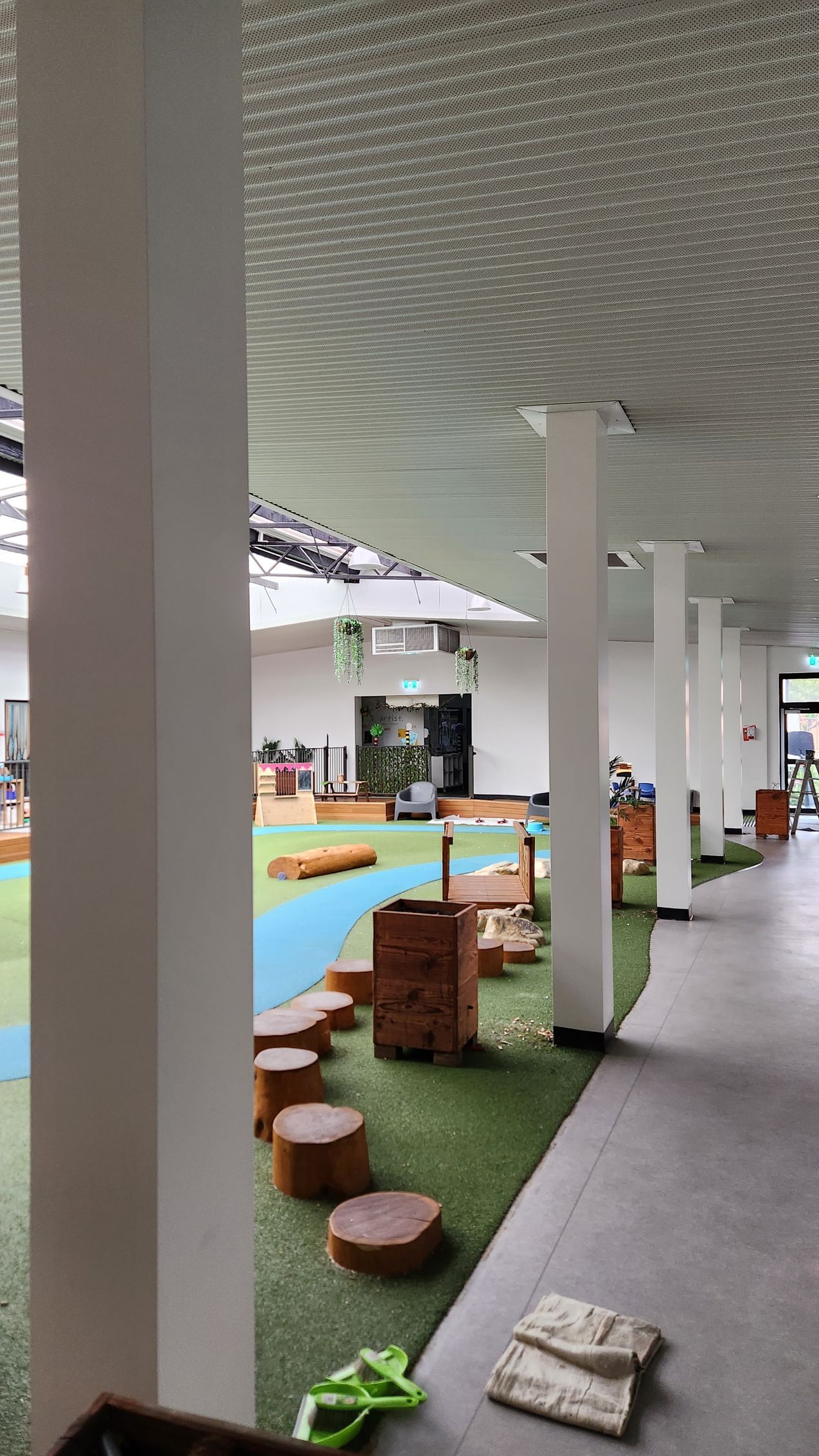 A large room with a lot of columns and a lot of toys on the floor.