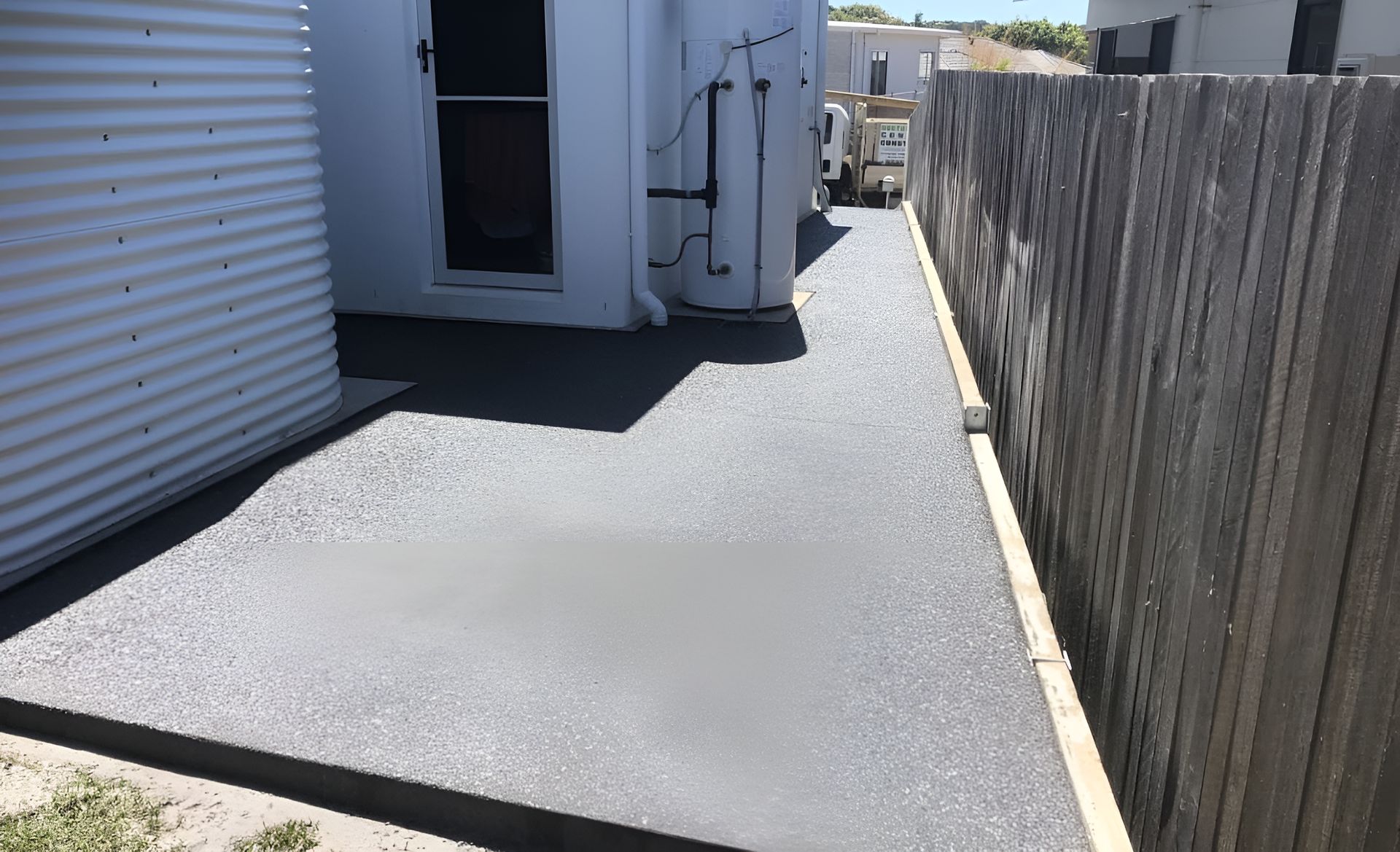 A Concrete Walkway Leading To A House Next To A Wooden Fence — Northern Rivers Concrete Construction In Pimlico, NSW
