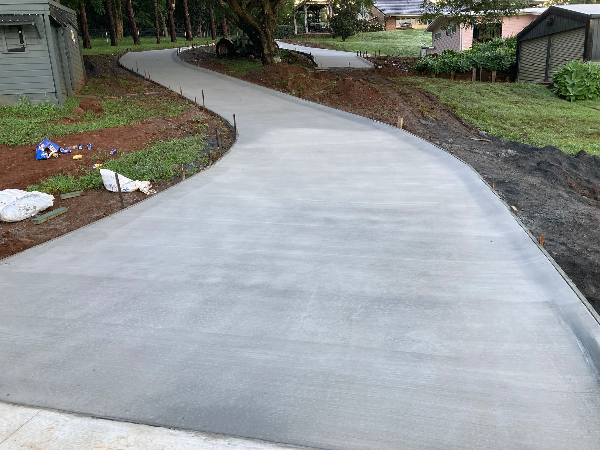 A Concrete Driveway Is Being Built In Backyard Of A House — Northern Rivers Concrete Construction In Pimlico, NSW