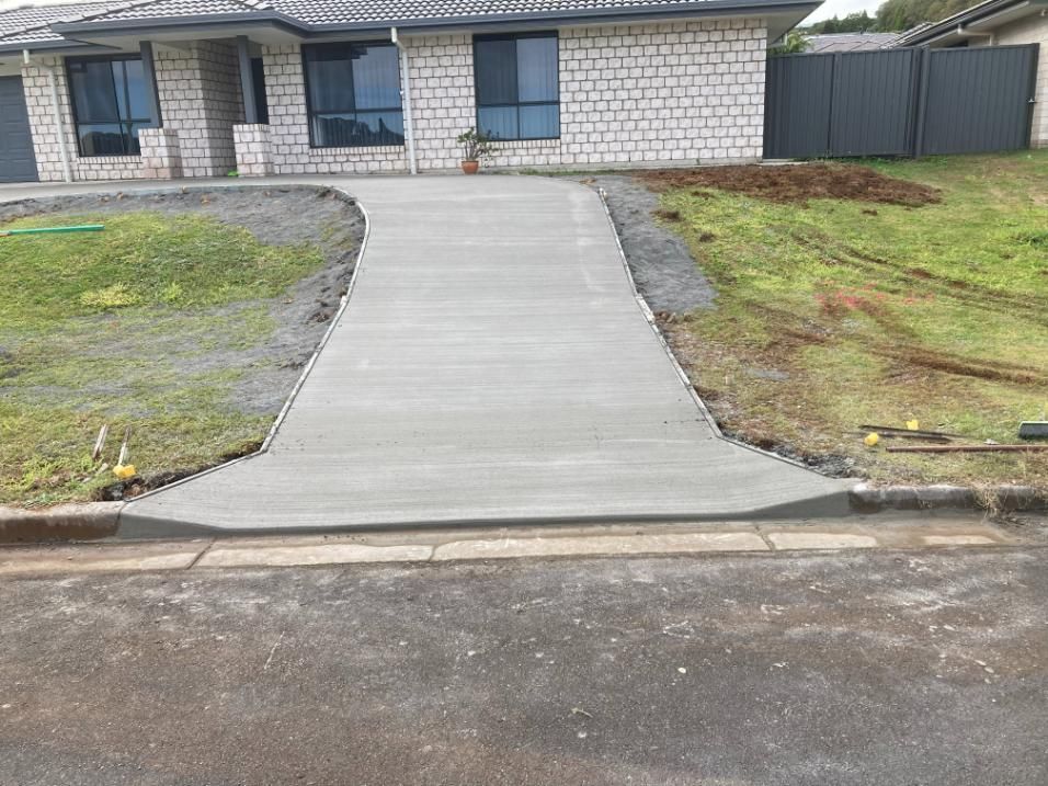 A Concrete Driveway Built In Front Of A House — Northern Rivers Concrete Construction In Pimlico, NSW