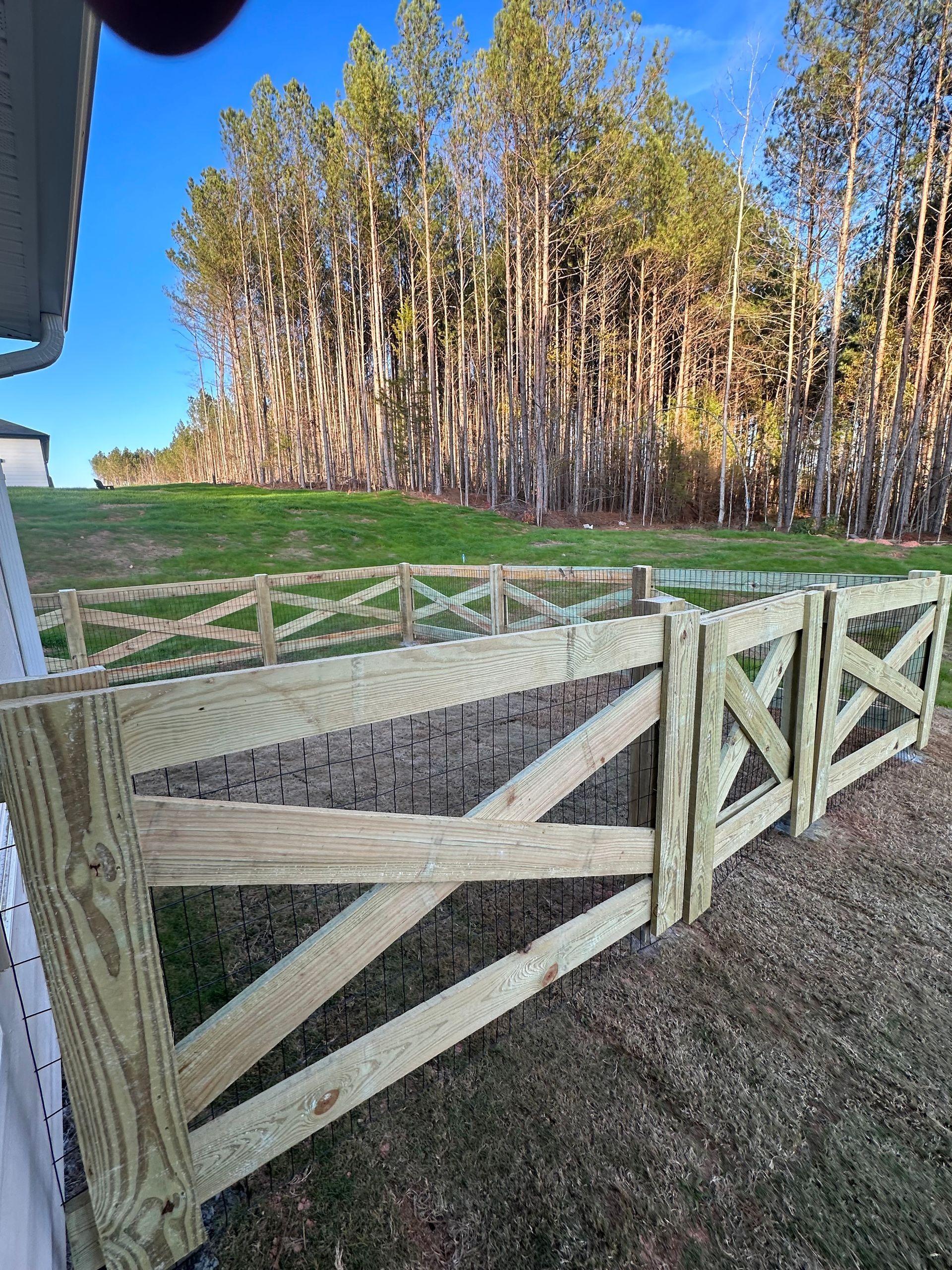 Nice wooden fence around house. Wooden fence with green lawn. Street photo, nobody, selective focus.