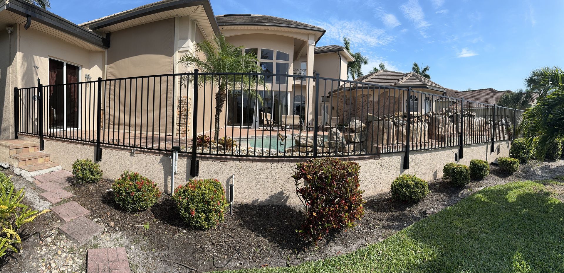 A large house with a fence around it and a swimming pool.