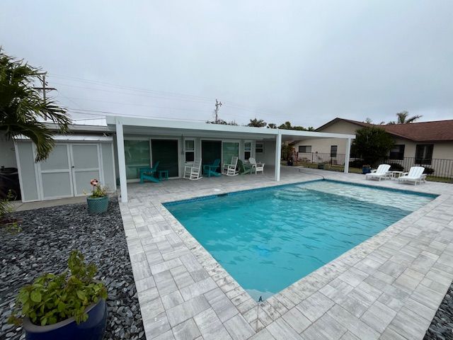 A house with a large swimming pool in front of it