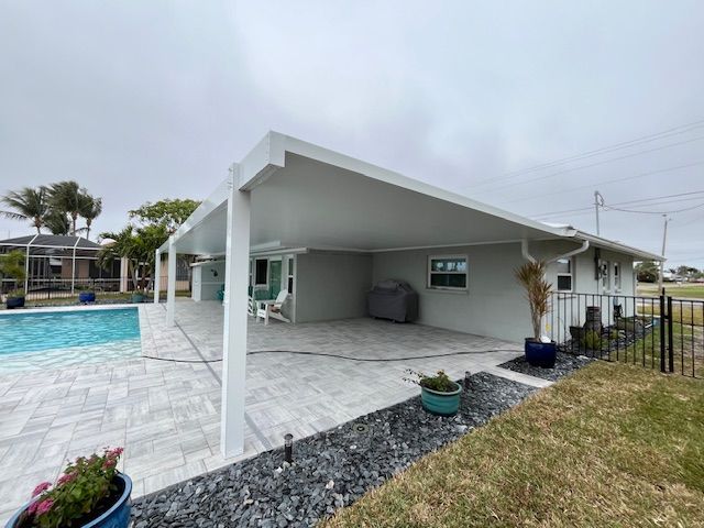 A house with a covered patio and a pool in the backyard.