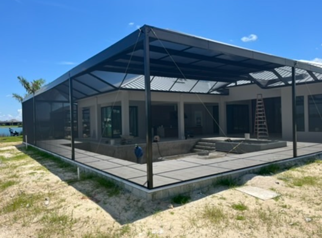 A house with a screened in porch and a pool.