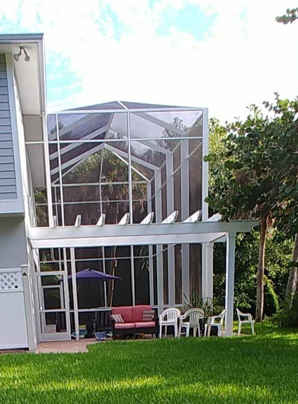 A house with a screened in porch with a couch and chairs