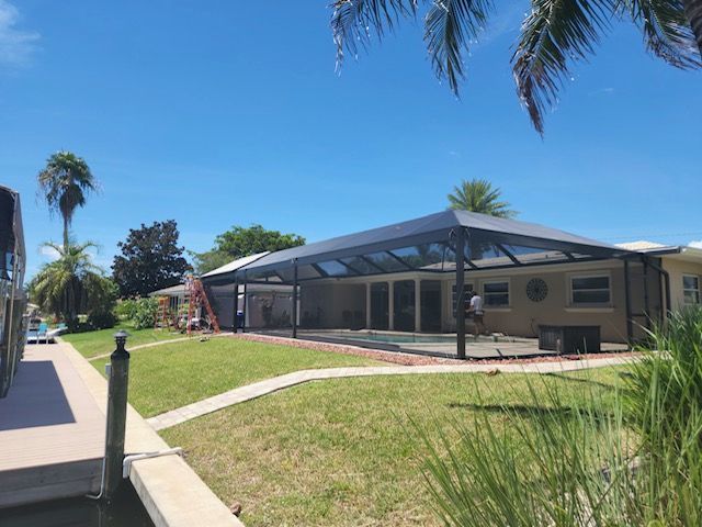 A house with a screened in swimming pool in the backyard.