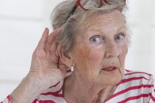 An Elderly Woman Wearing Glasses Holds Her Hand To Her Ear — Naturopath Australia In Mermaid Beach, QLD