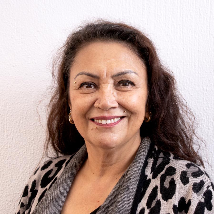 A woman in a leopard print sweater is smiling for the camera.