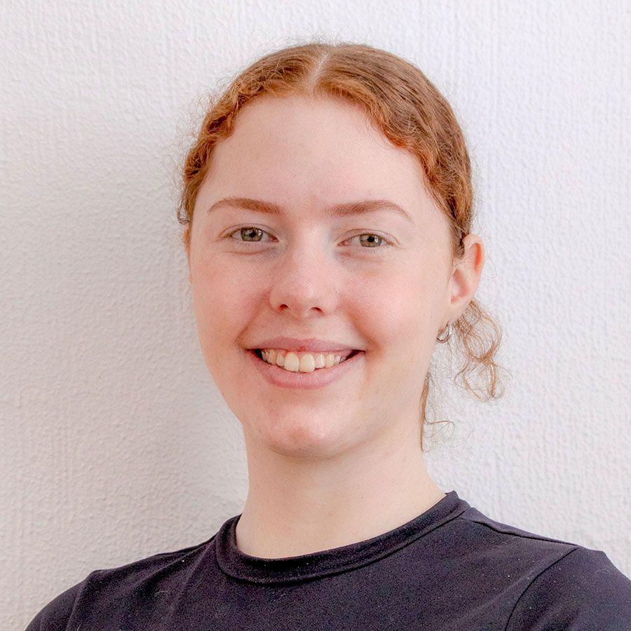 A woman with red hair is smiling and wearing a black shirt