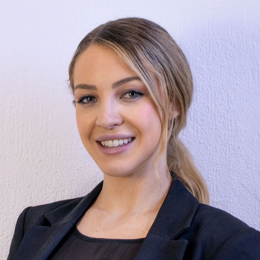 A woman in a black jacket is smiling for the camera