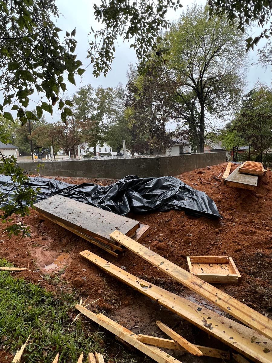 A pile of wood is sitting on top of a pile of dirt.